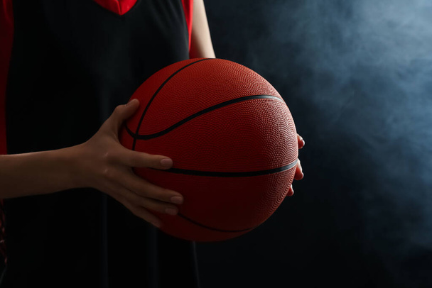 Basketball player with ball on black background, closeup - Valokuva, kuva
