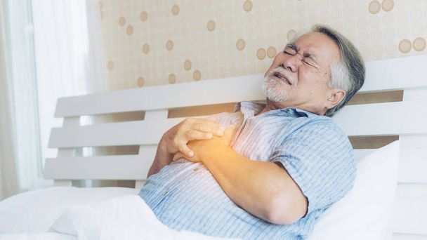 自宅で胸の心臓発作で痛みに苦しんでいるシニア男性アジア人-高齢者の心疾患 - 写真・画像