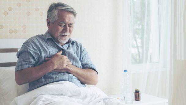 Hombre mayor asiático que sufre de dolor en el pecho ataque al corazón en casa - enfermedad cardíaca de alto nivel  - Foto, Imagen