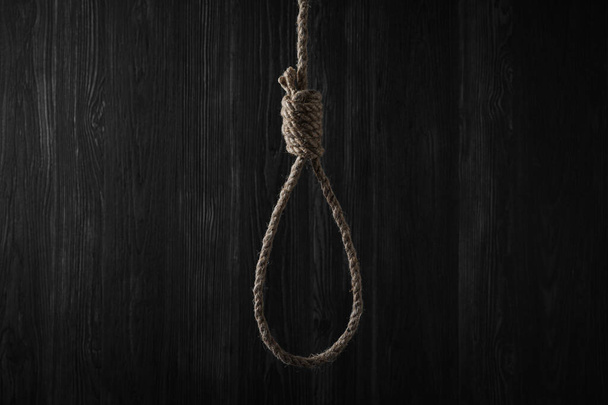 Tied rope noose against dark wooden background - Foto, Imagen