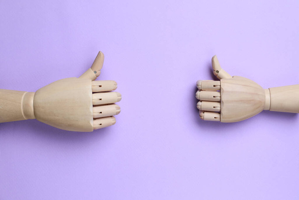 Wooden mannequin hands on lilac background, flat lay - Foto, Imagem