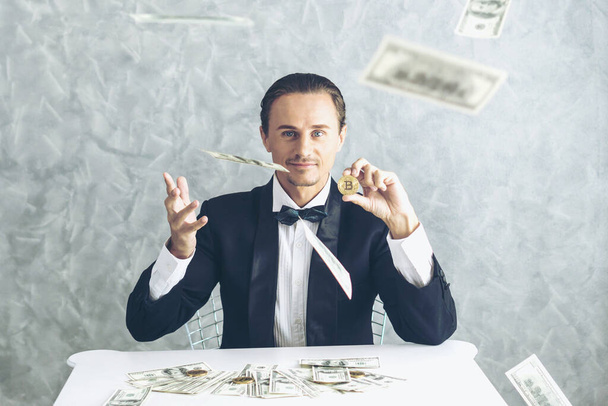 Üzletember gazdag kereskedő kezében bitcoin arany érme üzleti bitcoin kereskedő csere új valuta és bankjegyek USA dollár számla az asztalon üzleti koncepció - Fotó, kép
