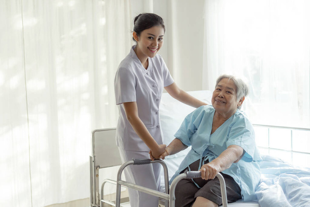 die Krankenschwestern sind gut versorgt, ältere Patienten im Krankenhausbett fühlen sich glücklich - medizinisches und medizinisches Konzept - Foto, Bild