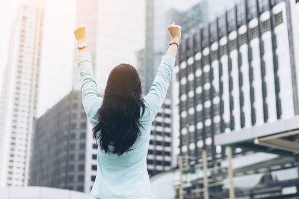 Successful business woman celebrating with arms up on business district , business concept - Photo, Image