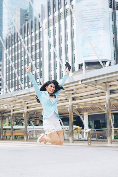 ビジネス街ビジネスコンセプトの成功と達成を祝う空気の中で幸せなジャンプを感じるライフスタイルアジアのビジネス女性. - 写真・画像