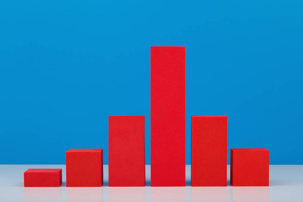 Business concept. Red chart with rise and fall dynamic against blue background. Chart for marketing, annual or corporate report and sales or growth evaluation or analytic  - Photo, Image