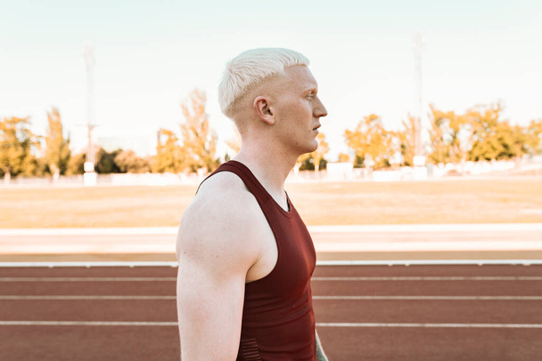 hombre atleta albino en una pista de carreras - Foto, Imagen