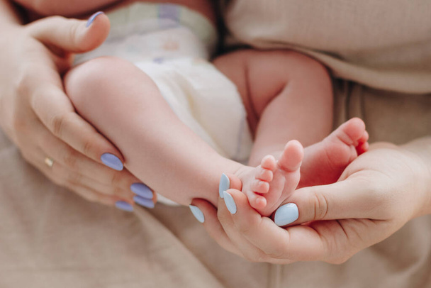 Mother holding baby feet in her hands - Fotoğraf, Görsel
