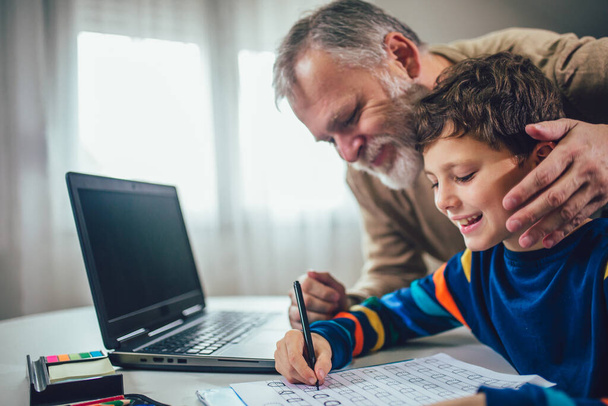 Enfant pratiquant l'écriture à la maison avec l'aide de son père - Photo, image