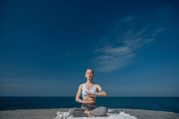Yoga ve meditasyon doğada var. Karadeniz yakınlarında çalışan bir kadın.. - Fotoğraf, Görsel