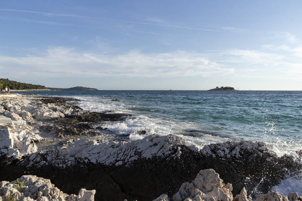 Waves trashng sharp rocky shore of Rogoznica, small tourist destination in central Dalmatia, Croatia - Photo, Image