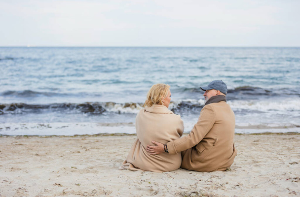 aged couple sitting on the beach - Φωτογραφία, εικόνα