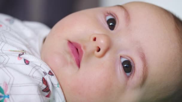 Το βλέμμα του μωρού στην κάμερα από κοντά. Ένα χαριτωμένο μωράκι κοιτάει στην κάμερα. Έννοια της φροντίδας των παιδιών, γονική αγάπη. - Πλάνα, βίντεο