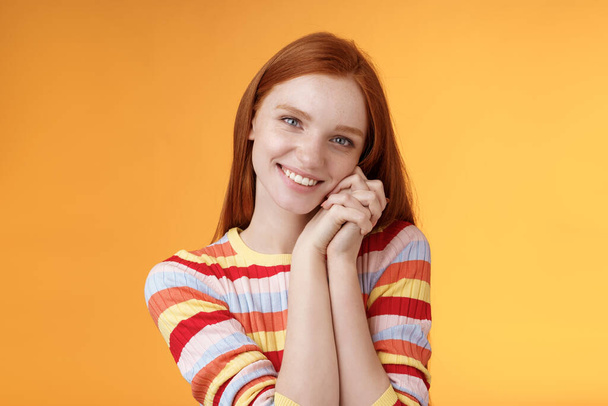 Romantic tender sensual attractive smiling redhead girlfriend melting heart feel warmth delighted lean palms grinning happily sweet gentle gift standing pleased orange background rejoicing thankful - Fotó, kép
