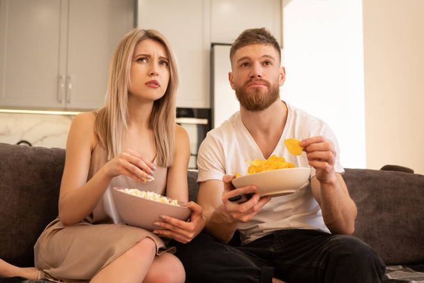 Couple sitting on sofa and watching TV or movie - Photo, Image