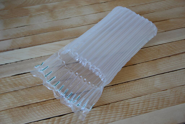 Embalaje inflable plástico a prueba de golpes de aire en el fondo de madera - Foto, Imagen