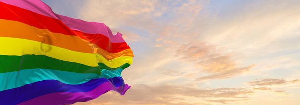 Original eight-stripe version flag waving in the wind at cloudy sky. Freedom and love concept. Pride month. activism, community and freedom Concept. Copy space. 3d illustration. - Photo, image