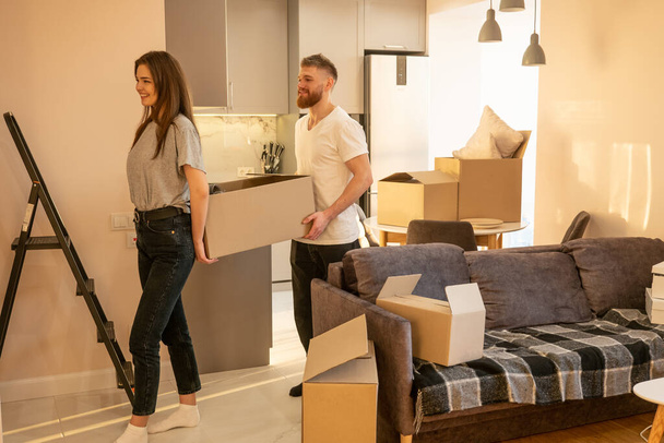 Couple carrying boxes with things at new home - Photo, Image