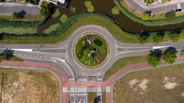 Vista aérea de arriba hacia abajo de una pequeña rotonda de tráfico en una carretera tranquila en los Países Bajos - Foto, imagen