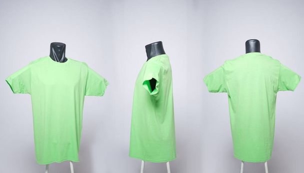 Hellgrüne T-Shirt-Vorlage für Männer, Drei-Wege-Ansicht, natürliche Form auf einer schwarzen Schaufensterpuppe, damit Ihre Attrappe gedruckt werden kann, isoliert auf einem schlichten weißen Hintergrund. Freier Platz für Ihre Anzeige. Unschärfe im Fokus. - Foto, Bild