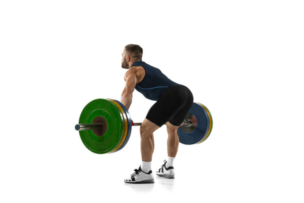 Portrait complet d'un homme en tenue de sport faisant de l'exercice avec un poids isolé sur fond blanc - Photo, image