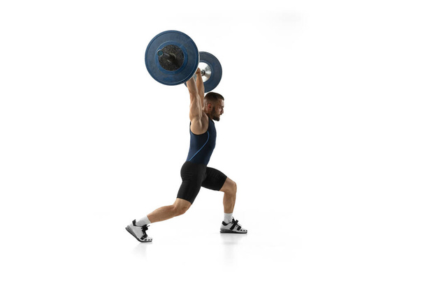 Full length portrait of a man in sportswear exercising with a weight isolated on white background - Photo, Image