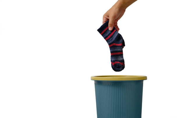 Man hand throws an old sock into trash on white background of isolate - Photo, image