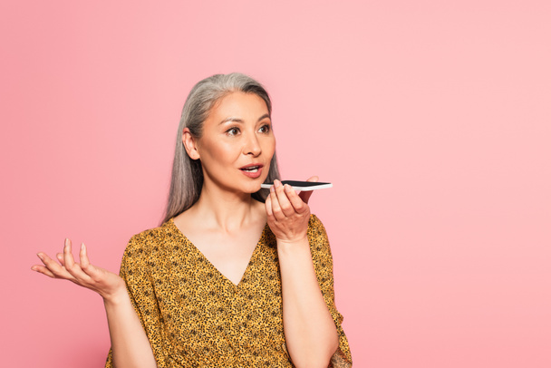 stylish asian woman with grey hair sending voice message isolated on pink - Foto, imagen