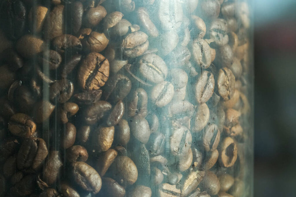 ヴィンテージカフェのガラスのフラスコの中の濃い焙煎コーヒー豆 - 写真・画像