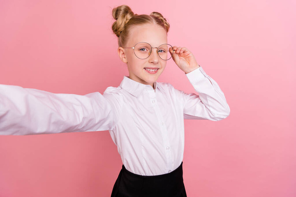 Photo of cute small girl do selfie wear white shirt spectacles isolated on pastel pink background - Foto, Bild