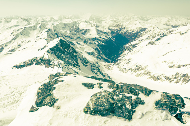 Rocher enneigé avec une vallée de montagne à l'arrière
 - Photo, image