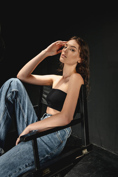 portrait of fashionable  young  woman   posing in studio on chair  - Φωτογραφία, εικόνα