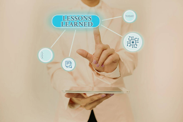 Text showing inspiration Lessons Learned. Word Written on the knowledge or understanding gained by experience Lady Holding Tablet Pressing On Virtual Button Showing Futuristic Tech. - Photo, Image