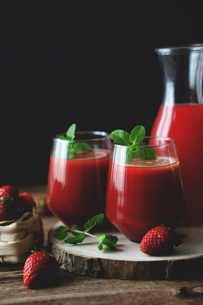 Close up view of two glasses of homemade refreshing strawberries juice nectar drink and mint - Foto, Bild
