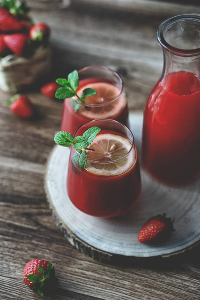 Vista de perto de dois copos de bebida de néctar de suco de morangos refrescante caseiro e hortelã - Foto, Imagem