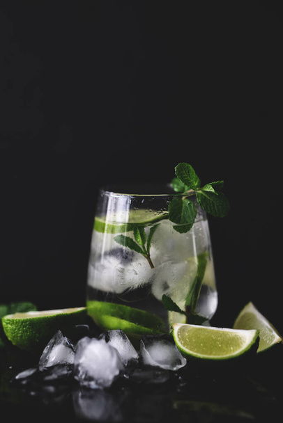 Vista da vicino del gin tonico rinfrescante fatto in casa con lime e menta fresca ricetta del cocktail estivo - Foto, immagini