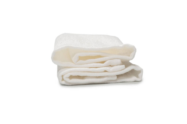 Witte pluizige katoenen handdoek geïsoleerd op een witte achtergrond. Spa en resort.  - Foto, afbeelding