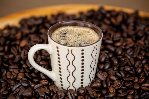 Κύπελλο με ζεστό καφέ κατ 'ευθείαν από το αγρόκτημα σε φρυγμένους κόκκους καφέ. - Φωτογραφία, εικόνα