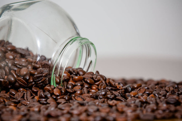 Verre avec poudre de café versé sur la table en grains directement de la ferme. - Photo, image