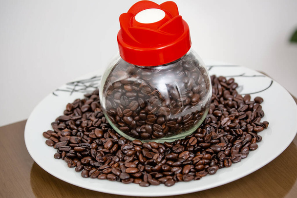 Sklenice s kávovým práškem nalitá na stůl v fazolích přímo z farmy. - Fotografie, Obrázek