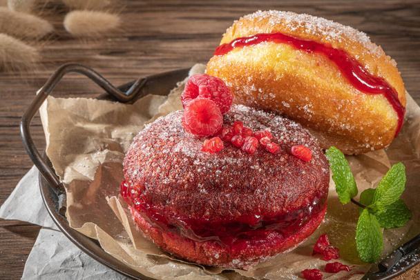 Bolas de Berlim, or "Berlin Balls". Portuguese fried dough with sugar, Filled with chocolate or raspberry jam. Portuguese fried dough with sugar. Chocolate and  beetroot  berliner Pancakes Doughnuts Donuts stuffed with various creams - Photo, Image