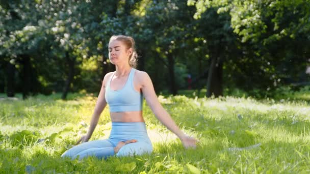 Athlète dame sportive en survêtement pratique l'exercice de yoga - Séquence, vidéo