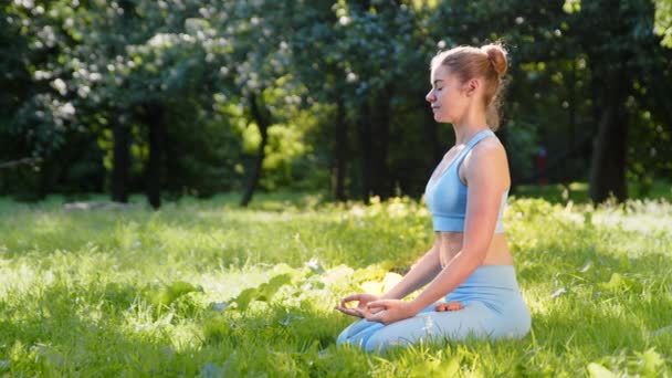 Mujer atleta en chándal practica yoga en pose de relajación - Imágenes, Vídeo