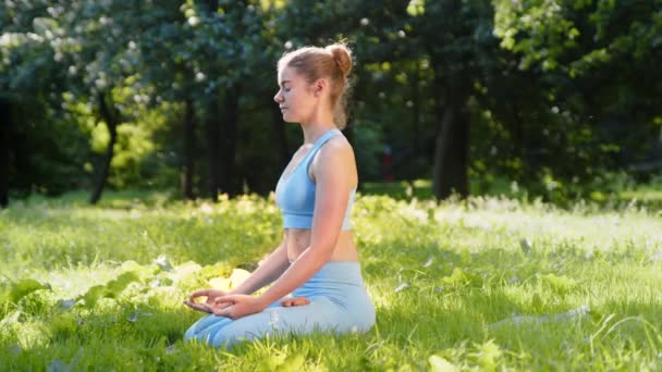Profesional practicante de yoga se sienta en pose de relajación - Metraje, vídeo