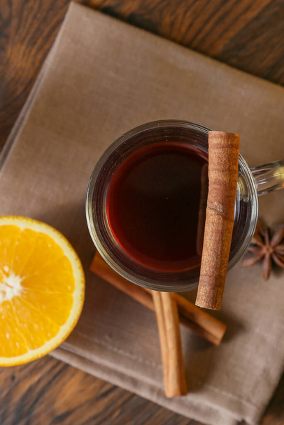 Mulled wine in glass cups with cinnamon and oranges on a wooden table. - 写真・画像