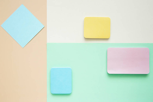 Blocks of bright multicolored blank stickers on a paper surface, top view. Geometric layout in pastel colors. Template, copy space. - Photo, Image