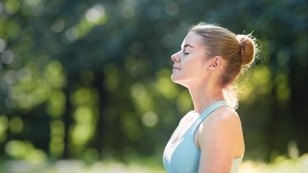 Mladá žena sportovec medituje zhluboka dýchá v létě - Záběry, video