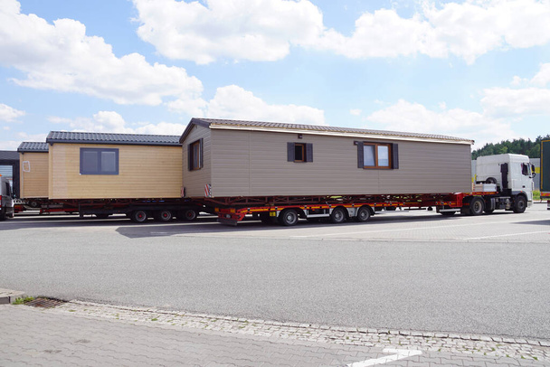 Oversized cargo or exceptional convoy (convoi exceptionnel). A truck with a special semi-trailer for the transport of oversized cargo - transport of finished houses. - Photo, Image