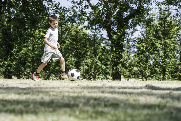 Child playing football in a stadium - Fotografie, Obrázek