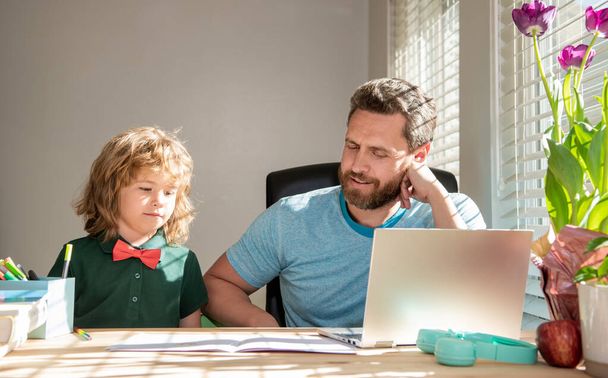 érett férfi tanár vagy apa segít gyerek fia iskolai házi feladatot a számítógépen, vissza az iskolába - Fotó, kép